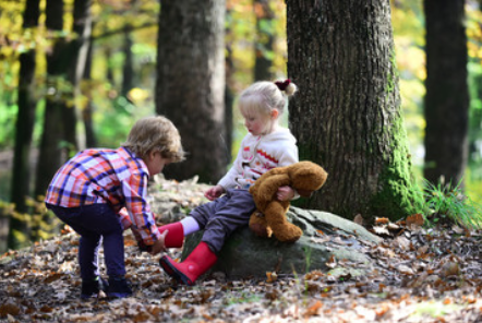 toddlers helping each other with shoes